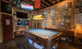 The pool table area with decorative photos hanging on the walls