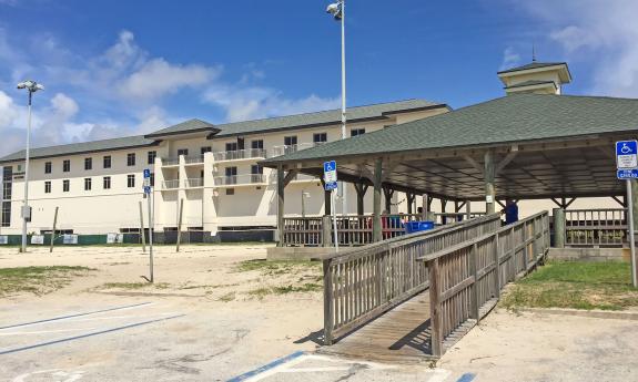 A ramp leading up to the covered pavilion with the volleyball courts beside it