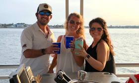 Three friends raise a glass on the BYOB Red Boat tour