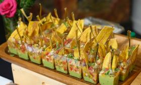 Individual tapas featuring guacamole on a tray prepared for serving