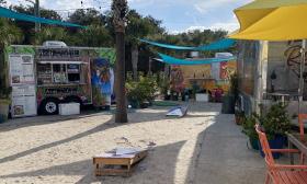 The center of the food truck area and corn hole sand area