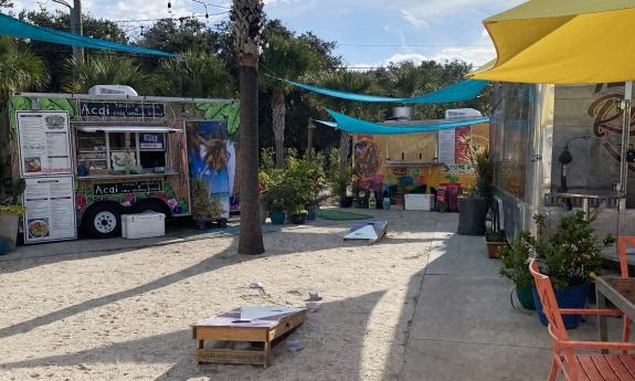 The center of the food truck area and corn hole sand area