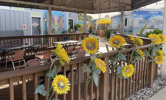 A covered seating section decorated with sunflowers on the rails