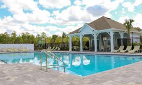 The pool and covered patio at St. Augustine Lakes, surrounded by greenery