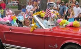 A red convertable, covered with Easter stuffies in the Easter parade