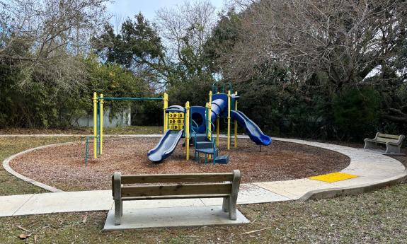 There is a playground with park benches surrounding the area