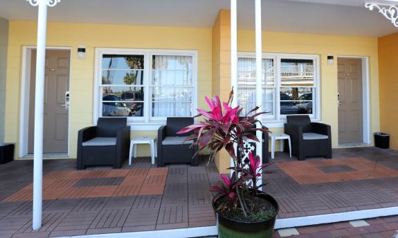 The first floor walkway and deck at the Marion Motor Lodge has yellow walls, and comfortable seating