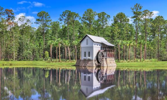 The entrance to Mill Creek Forest with a traditional mill house and water wheel