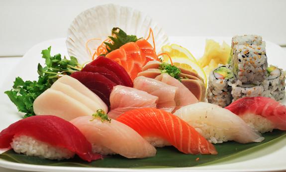 A platter of various sushi rolls and different types of fish