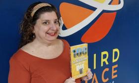 100 Things to Do in St. Augustine Before You Die author holds a copy of the book at Third Space Improv