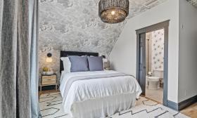 Apartment 3, under the eaves, has a wallpaper cloud ceiling and grey and white decor