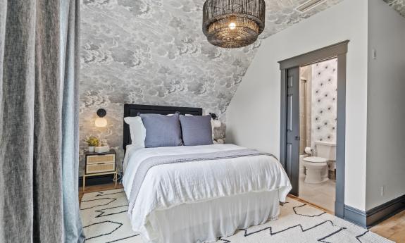 Apartment 3, under the eaves, has a wallpaper cloud ceiling and grey and white decor