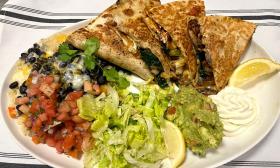 A blackened shrimp quesadilla dish with pico and guacamole on the side