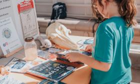 A young girl looks at the educational materials aboard a Florida Water Warriors cruise