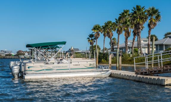 Pontoon boats for rent at Devil's Elbow, tied to a dock on the river