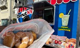 A bag of cinnamon sugar donuts held up in front of the food truck