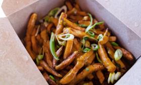 Curry French fries with garnishes sprinkled on top