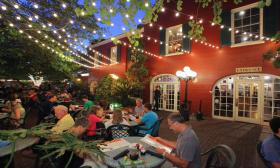 Visitors enjoy dinner under the white lights on Harry's patio