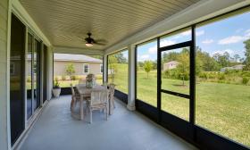 A screened-in back porch overlooking the yard