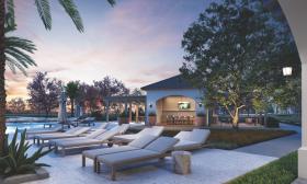 The lounge area near the pool at Soluna Apartments is adjacent to a yoga lawn and covered yoga area