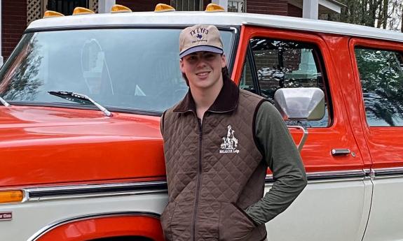 Musician Davis Cook, smiling, in front of truck