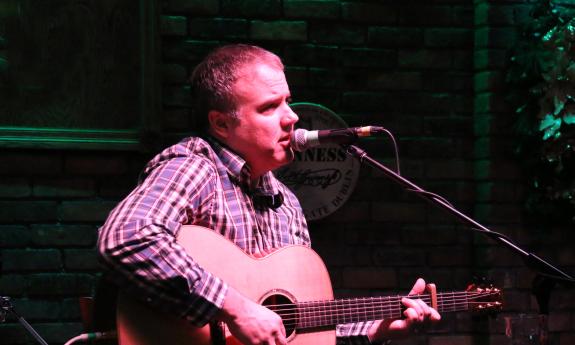 Jimmy Bragg performing with guitar on stage