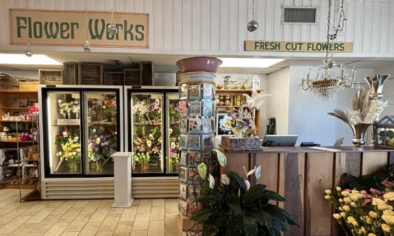 Flowers arranged in a fridge behind the counter