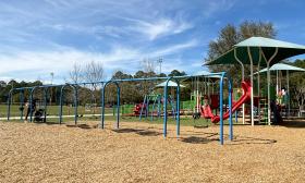 The playground has a swing set and various slides