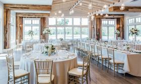 Chic wedding dining setup with natural and modern lighting inside St. Johns Golf & Country Club
