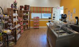 The back of the shop has a gelato/coffee counter and shelves of various treats