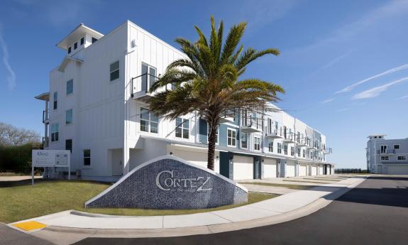 The entrance to Cortez on the Water includes their sign, a building and a sunny day with blue skies