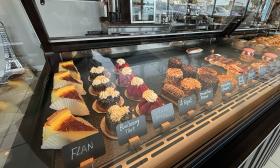 An assortment of desserts in a glass display