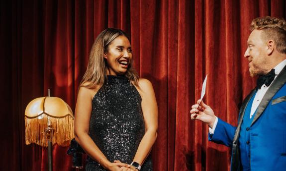 Master Magician Bill Abbott shows a note card to a woman from the audience