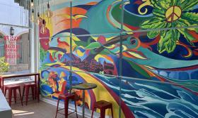 Indoor seating along a colorful, groovy mural