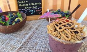 An acai bowl topped with granola, peanut butter, and fruits