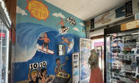 A mural of surfers near the entrance of the shop