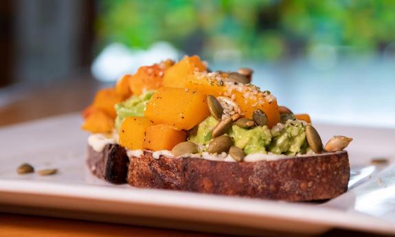 A plate of avocado toast with various toppings