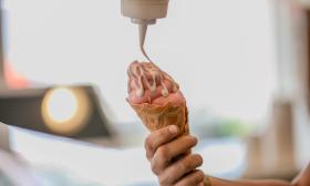 An employee decorating an ice cream cone