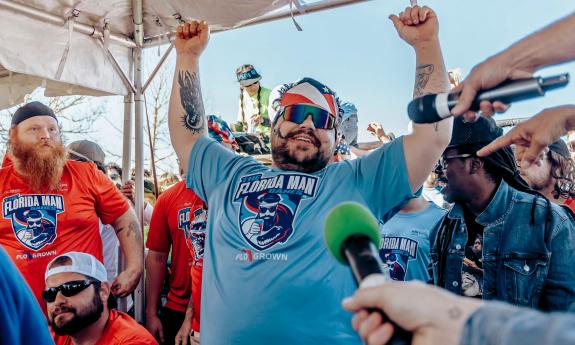 A man celebrating his win surrounded by the media