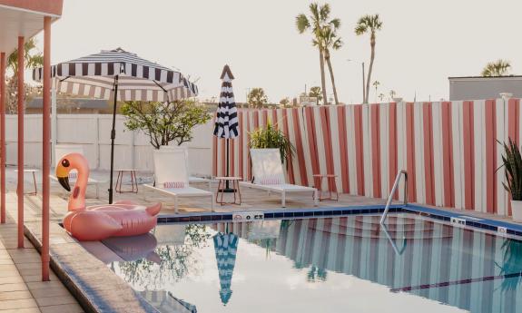 There is a spacious pool with lounge chairs and umbrellas on the deck