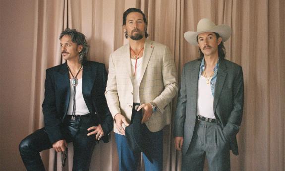 Bandmates from Midland pose in front of a beige backdrop. 