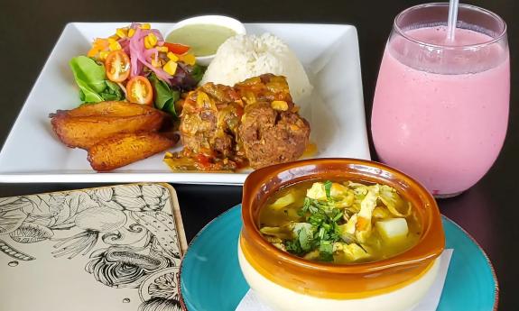 A plate of meatballs, rice, plaintains, and a bowl of tortilla soup