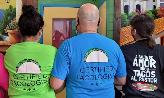 The staff shows off the restaurant's T-shirts