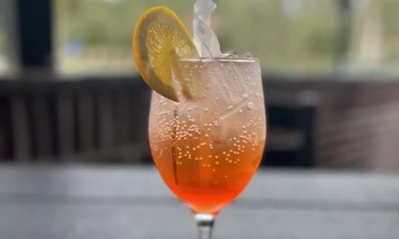 A cocktail beverage topped with a lemon