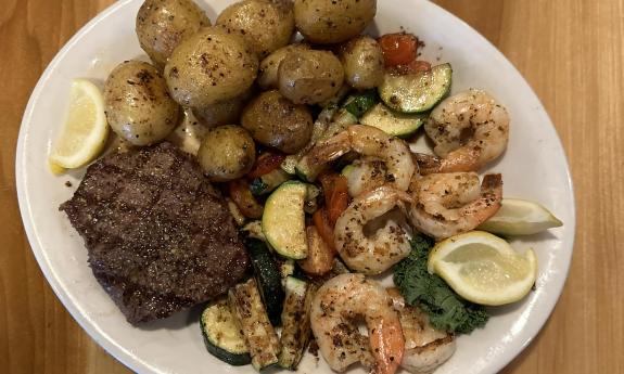 A platter of shrimp, meat, and potatoes
