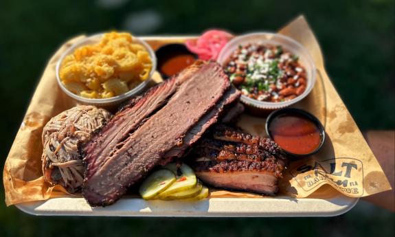 A tray of meats, mac 'n' cheese, and baked beans