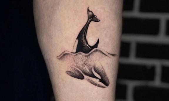 A black and grey whale tattoo