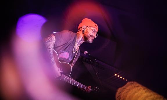 Drew McManus of Satsang on stage, haloed by pink lights