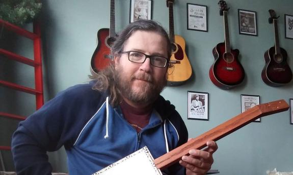 Luthier Kevin Edwards playing one of his cigar box guitars