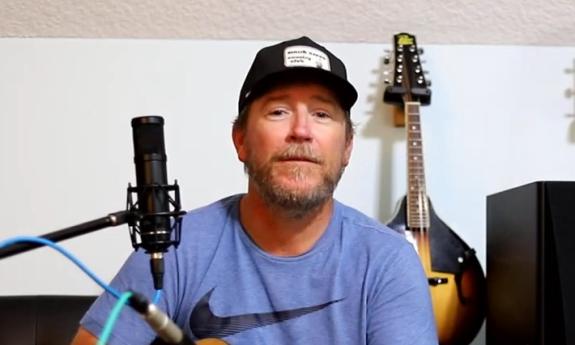 Singer songwriter Kevin Edwards in a studio, behind a microphone